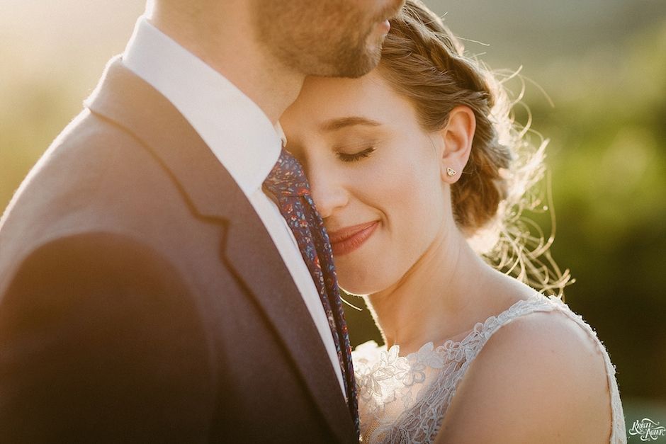 A bride and groom are hugging each other on their wedding day.