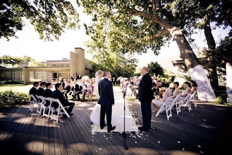 A bride and groom are getting married in front of a crowd