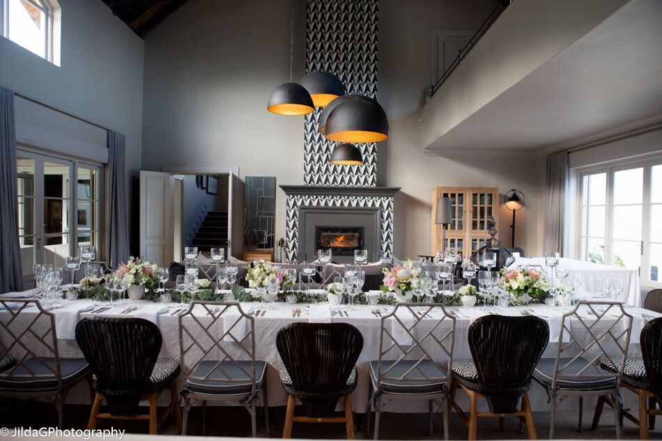 A large room with a long table and chairs and a fireplace.