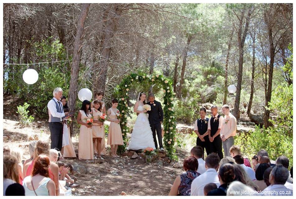 A bride and groom are getting married in the woods.