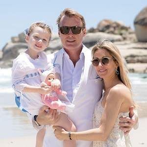 A family is posing for a picture on the beach.