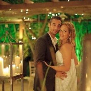 A bride and groom are posing for a picture at their wedding reception.
