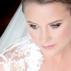 A close up of a woman wearing a wedding dress and veil