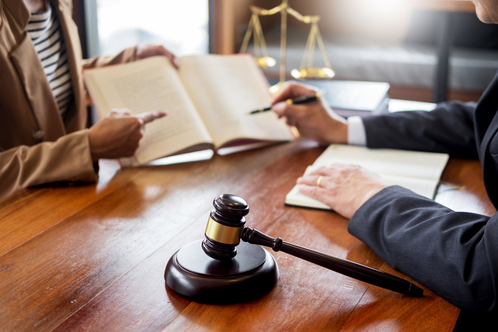 Lawyers at a table reviewing documents, gavel, and scales of justice.
