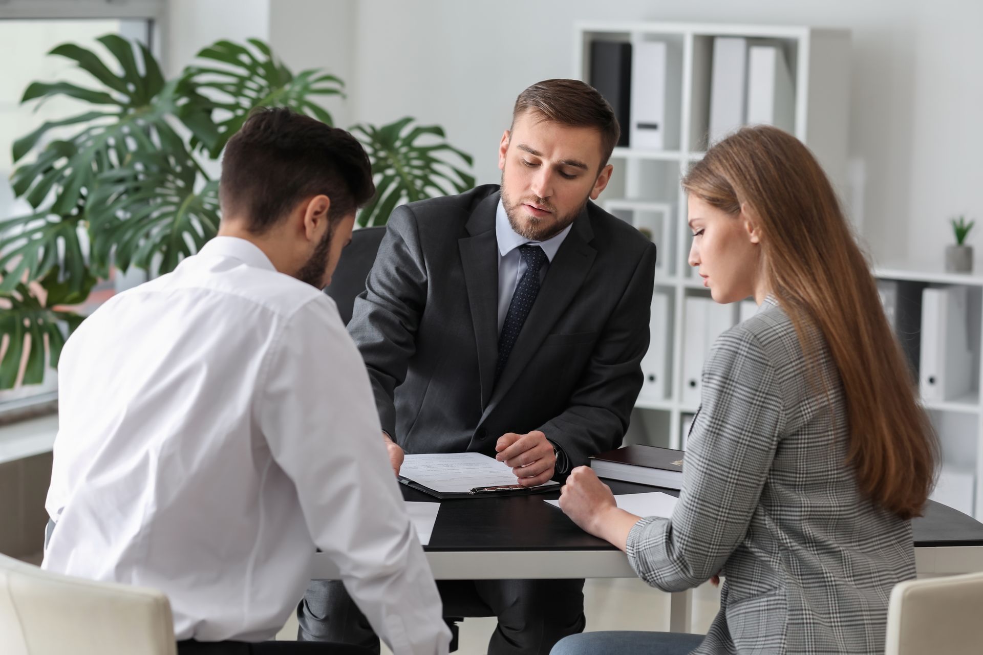 Unhappy young couple visiting divorce lawyer in office.