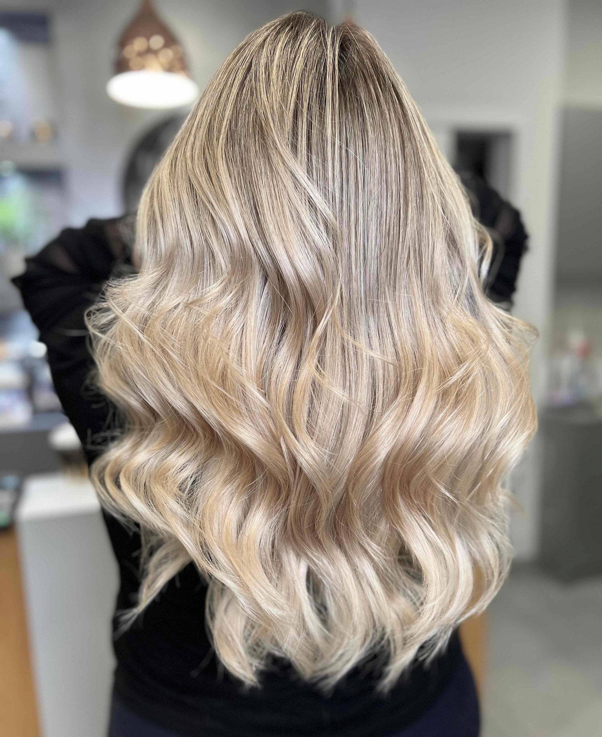 Woman With Long, Wavy Blonde Hair; Hair Styled With Textured Roots and Highlights — Artistry Of Hair in Redlynch, QLD