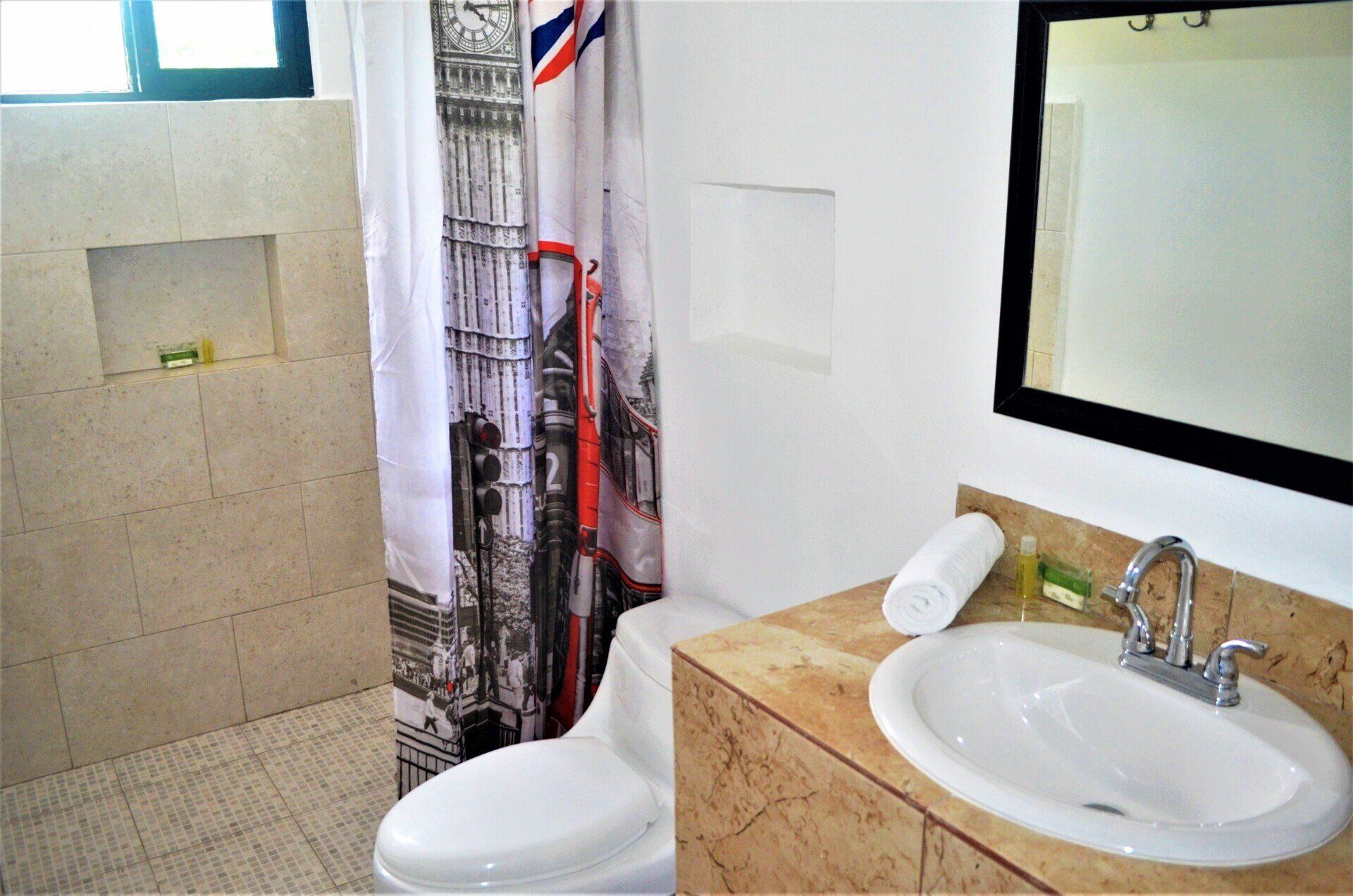 A bathroom with a toilet a sink and a shower curtain