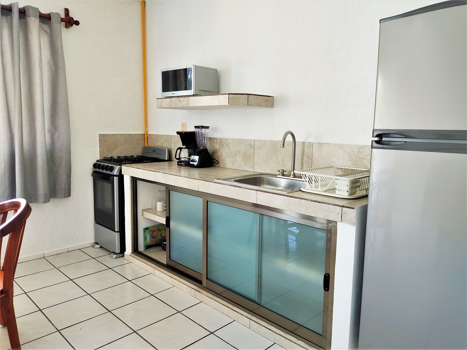 Una cocina con frigorífico de acero inoxidable y fregadero.