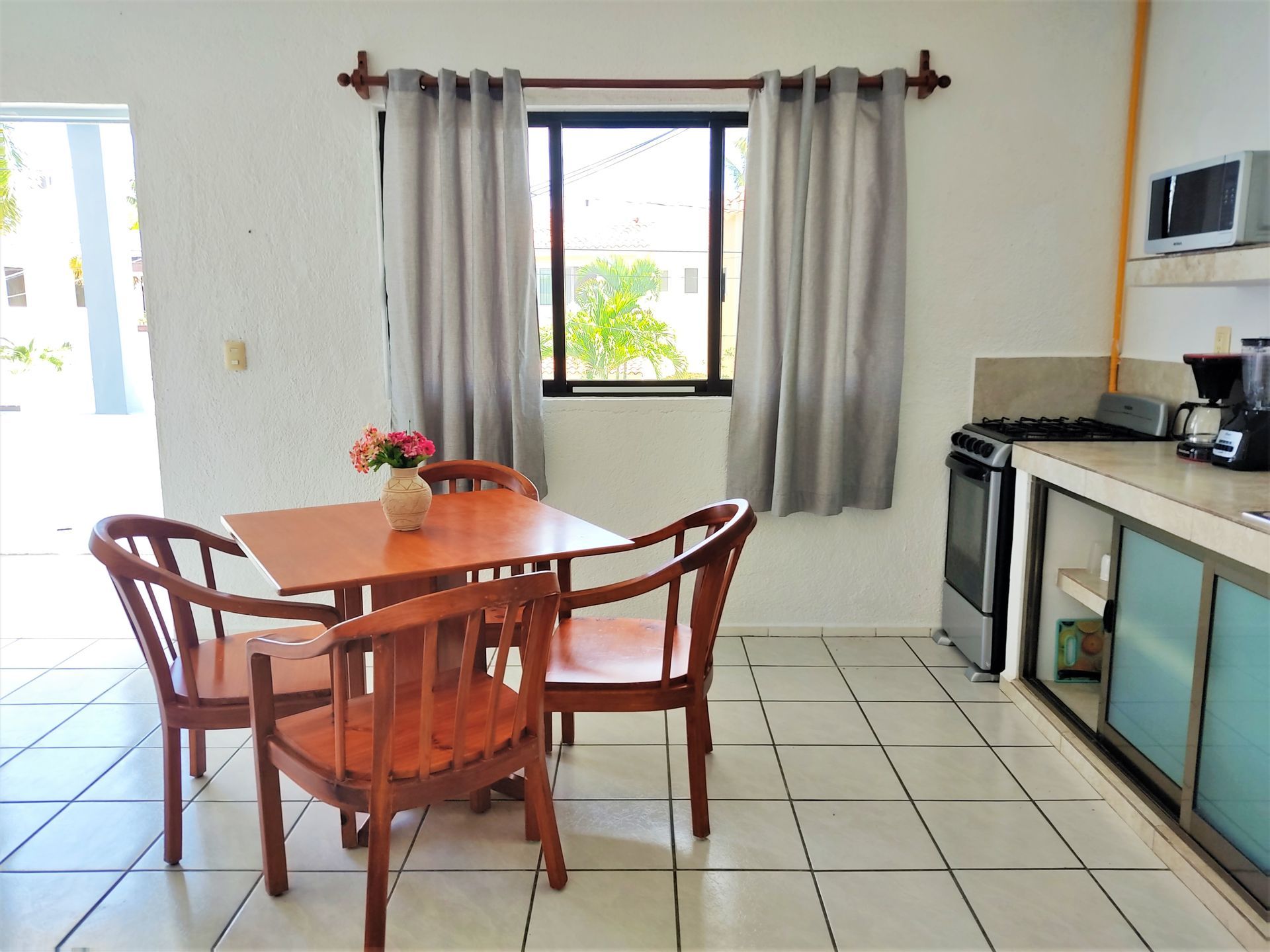 Una cocina con mesa y sillas y una ventana.