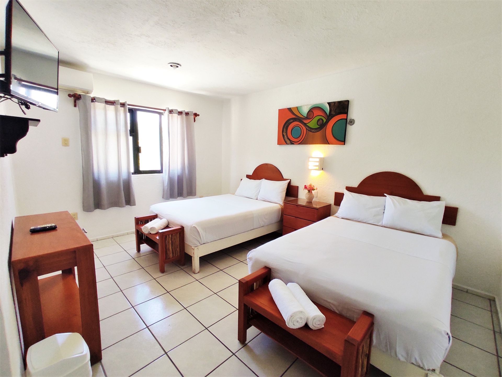 A hotel room with two beds and a flat screen tv