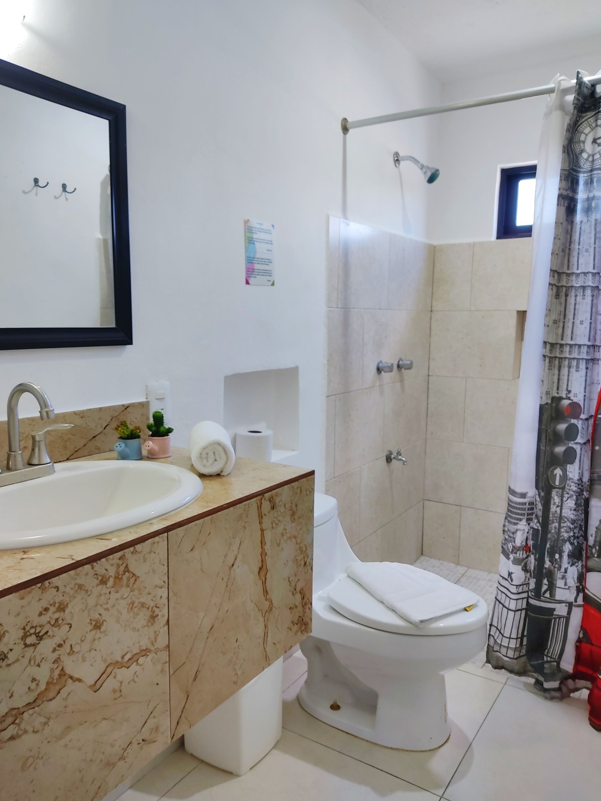 Un baño con inodoro, lavabo y ducha.