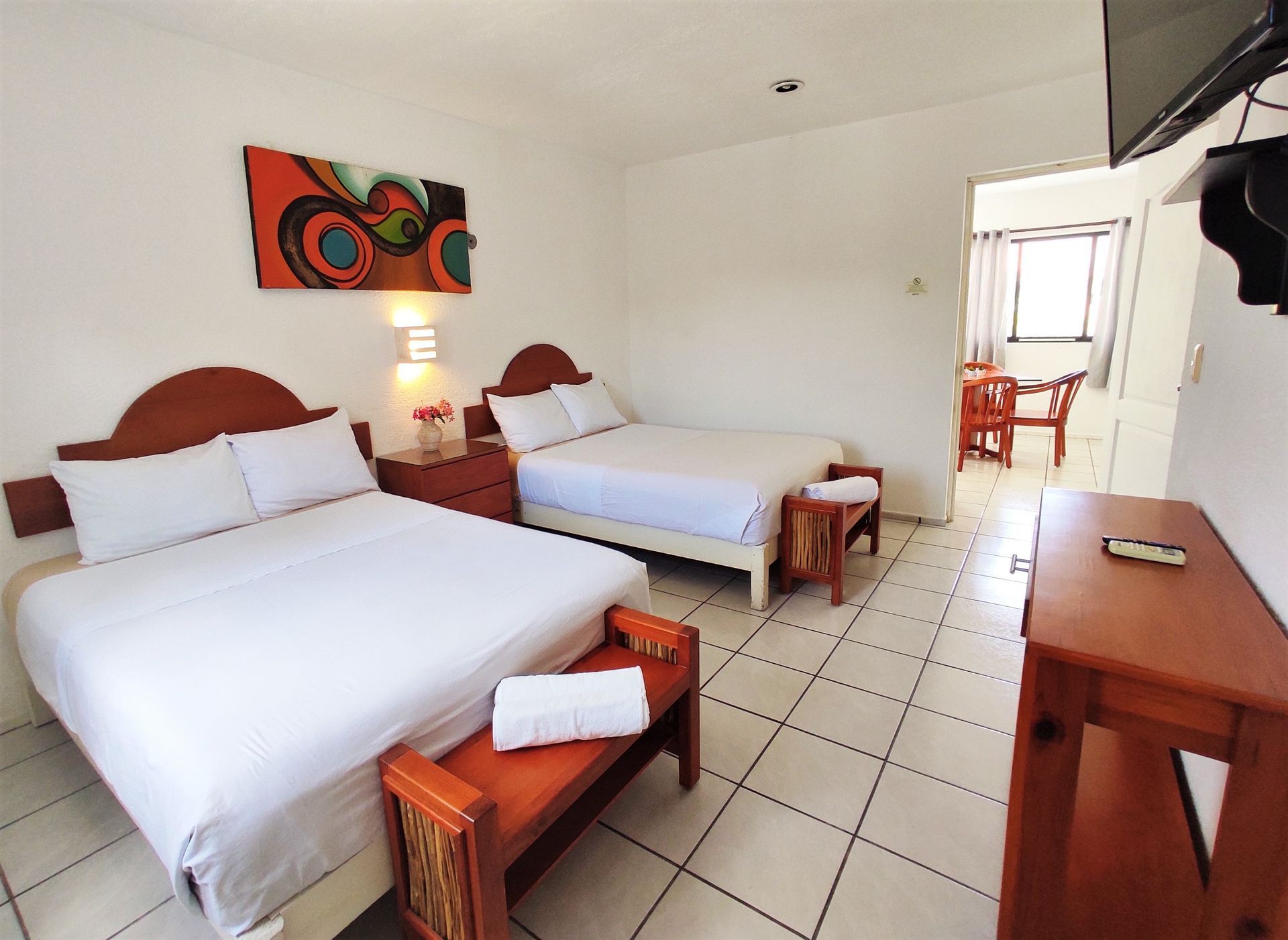 A hotel room with two beds and a television