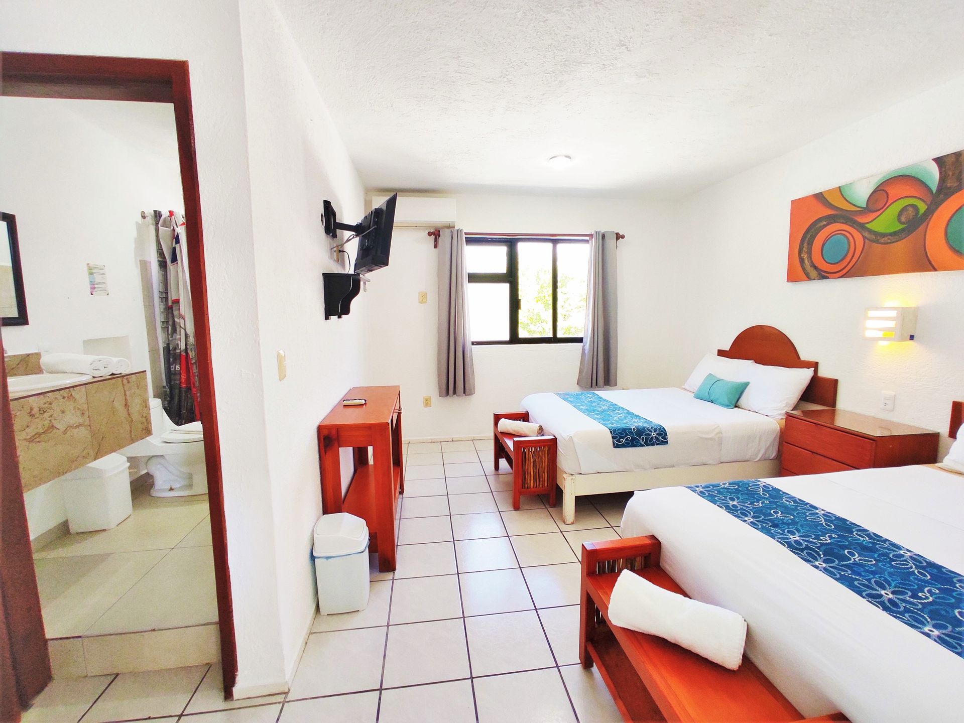 Una habitación de hotel con dos camas y un baño.