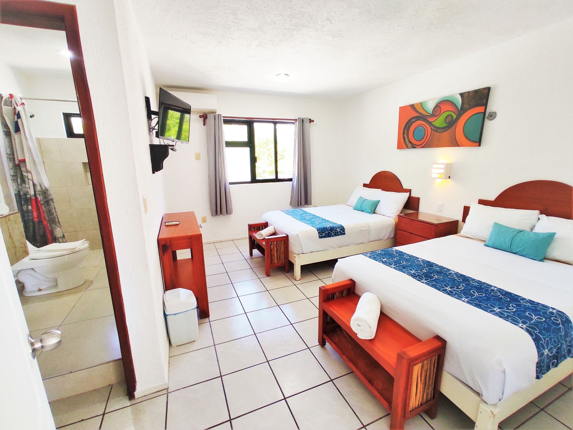 Una habitación de hotel con dos camas y un baño.