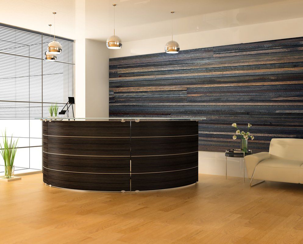 Modern office lobby with curved black reception desk, wood floor, lounge chair, and blue wall art