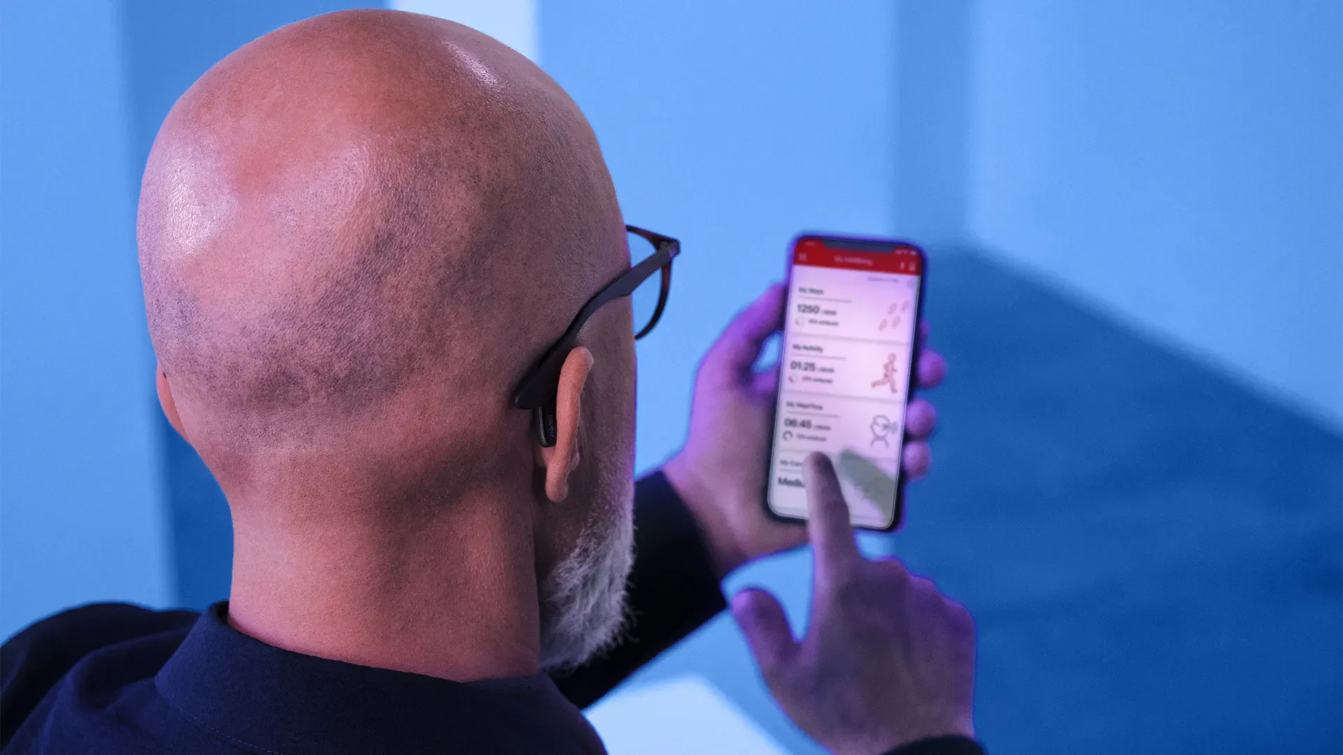 Man looking at a smartphone screen with health data. The background is blue.