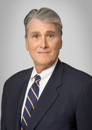A man in a suit and tie is smiling for the camera.