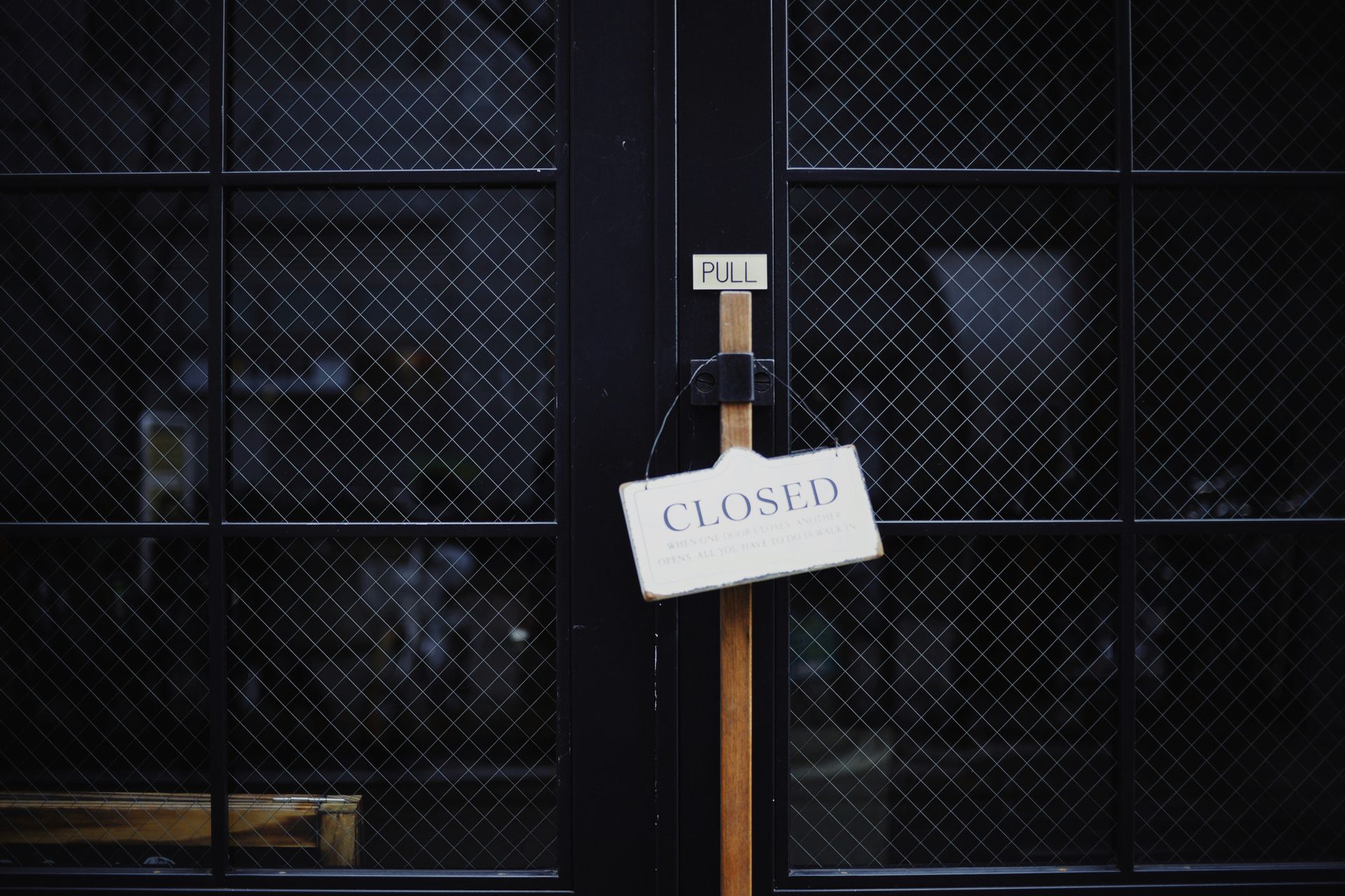 A closed sign is hanging on the door of a building.