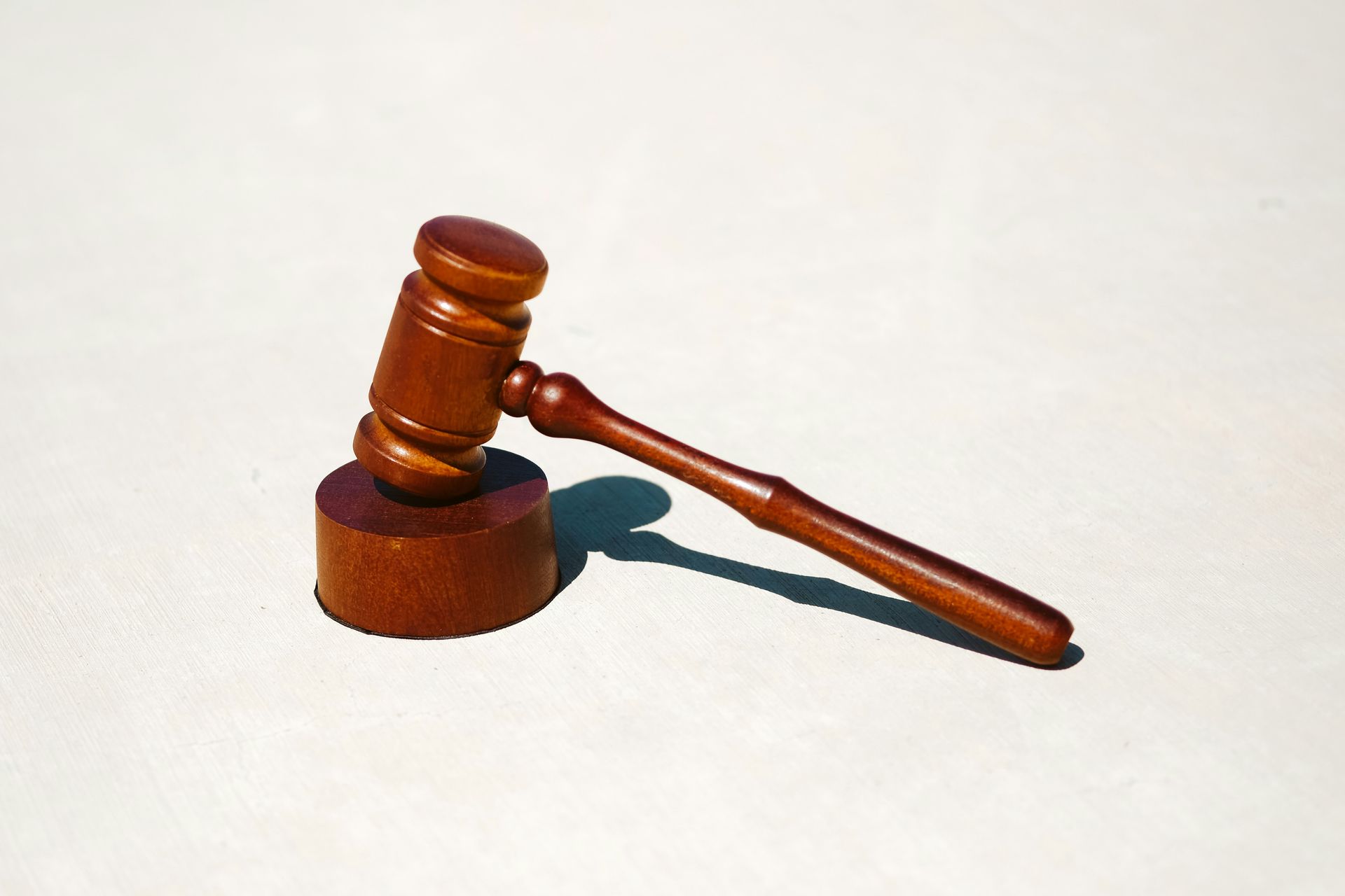 A wooden judge 's gavel is sitting on a white surface