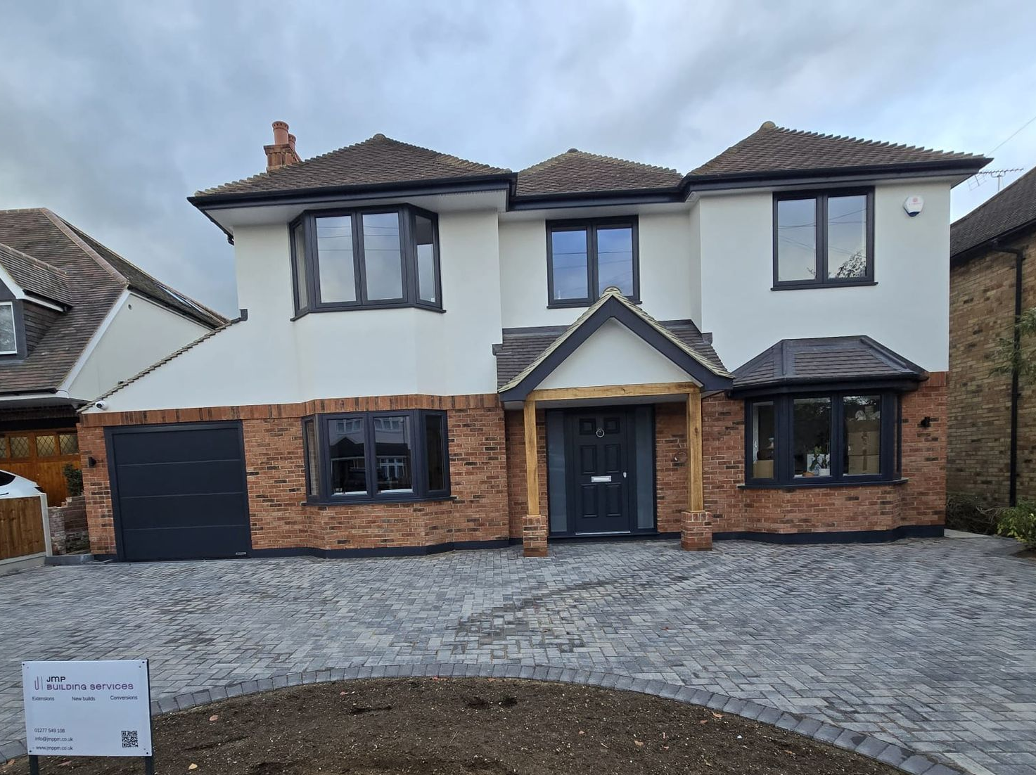 Front view of a newly built two-story house with brick and white exterior and a paved driveway
