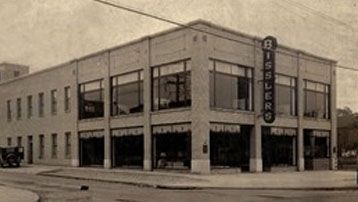 A black and white photo of a large brick building with a sign that says bissel on it.