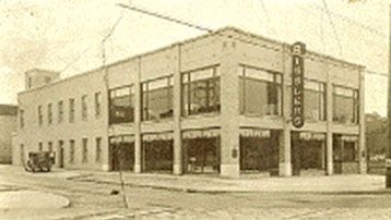 A black and white photo of a large building with lots of windows.