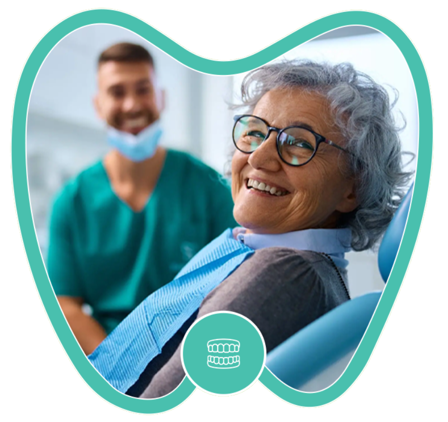 A person smiling in a dentist's chair while a dental professional stands in the background.