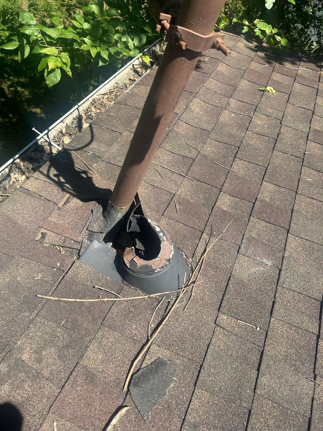 A brown pipe is sitting on top of a brick roof.