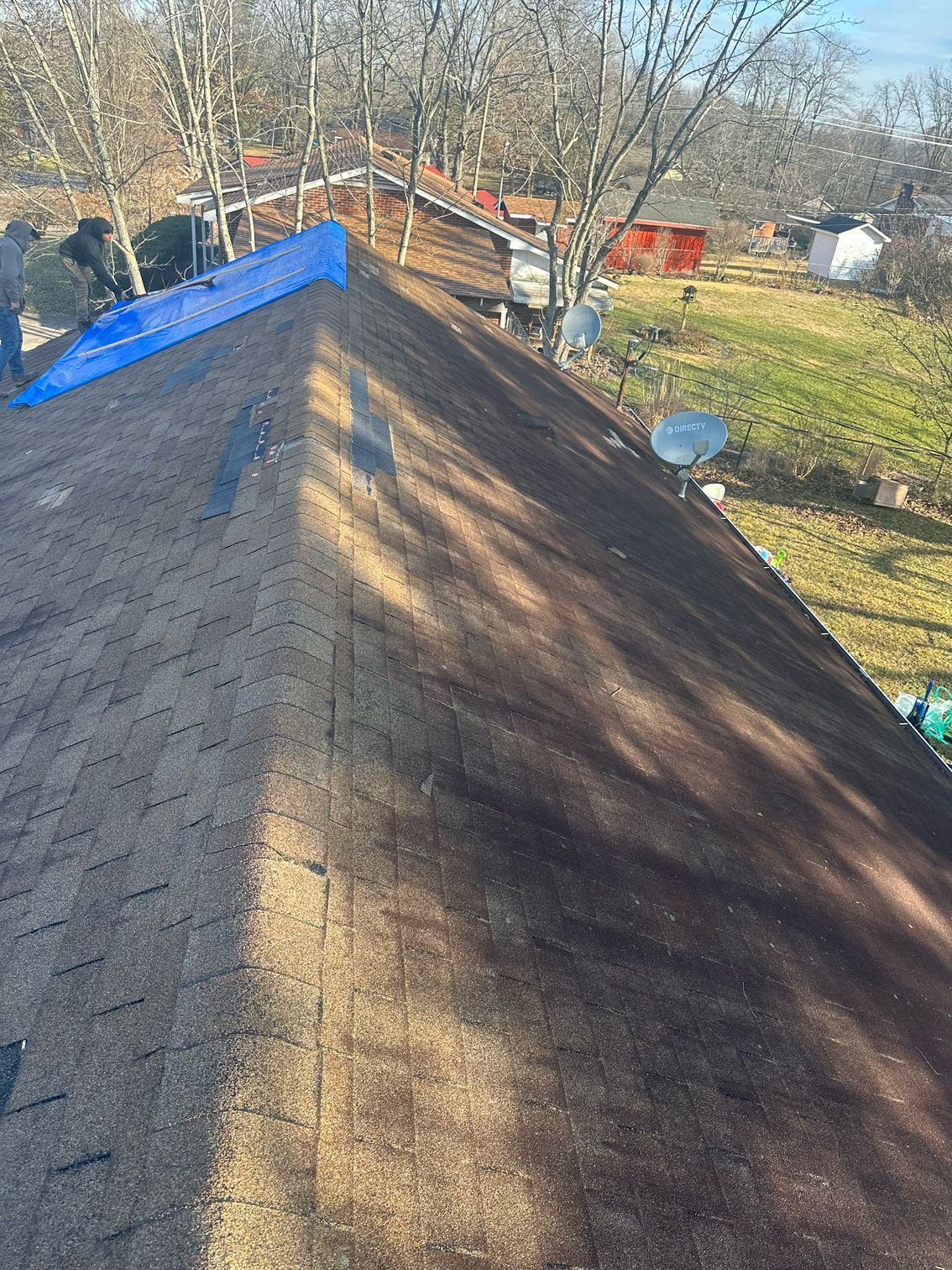 A man is working on the roof of a house.