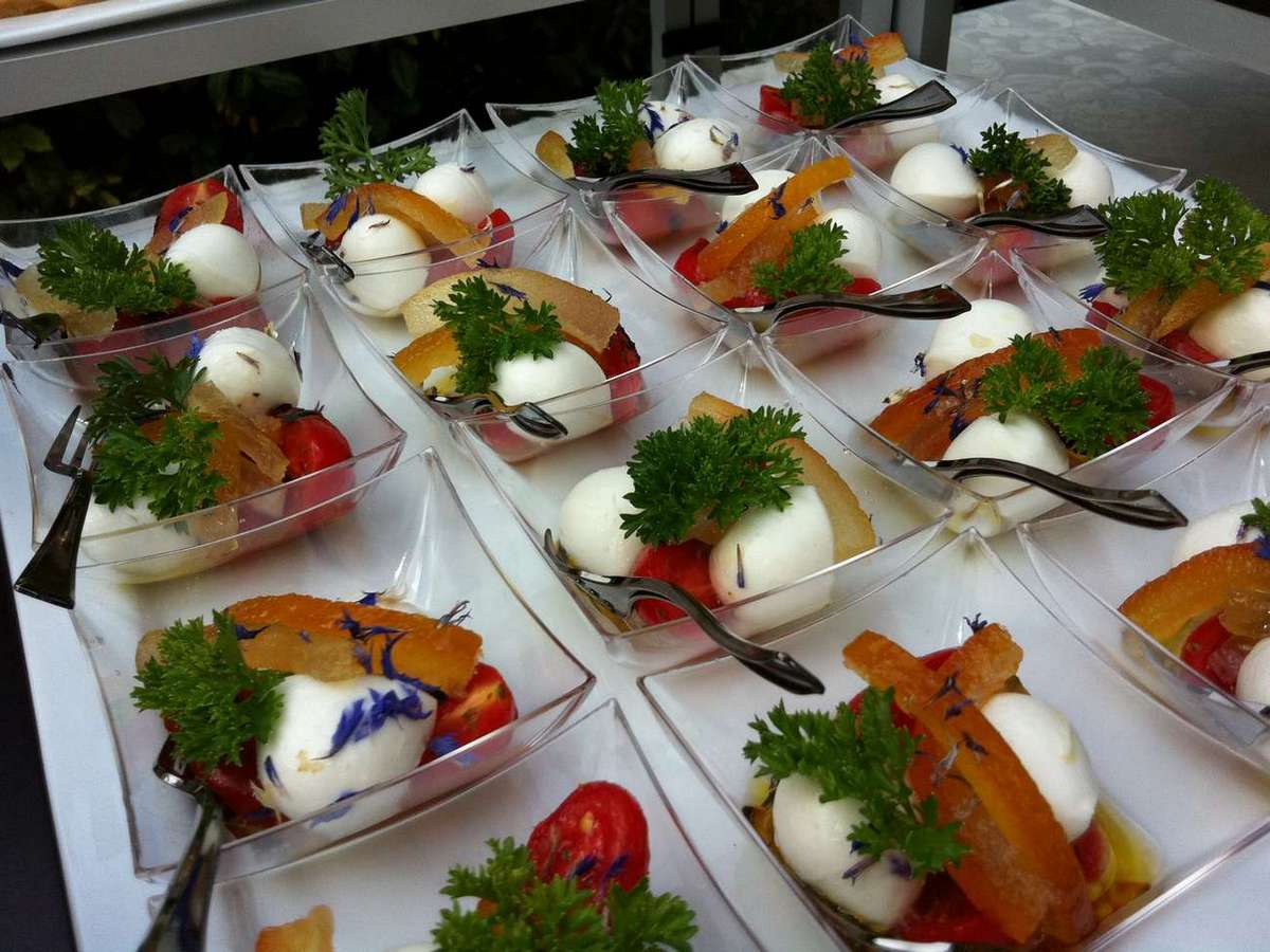 Un vassoio di antipasti con mozzarella, pomodori e prezzemolo