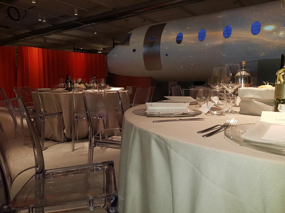 Un tavolo apparecchiato per una cena con un aereo sullo sfondo.