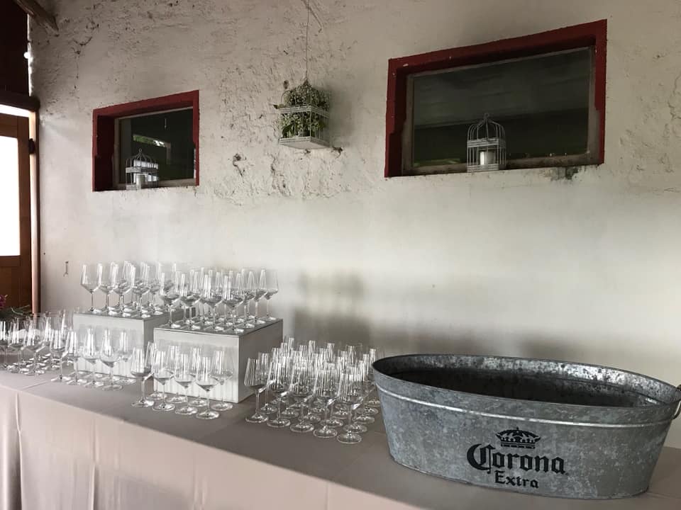 Un tavolo con sopra un secchio di birra Corona e bicchieri di vino.