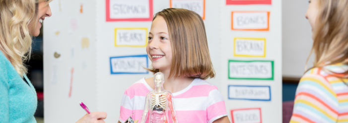 Middle school student presenting a biology project to teachers and classmates at Sandwich Montessori