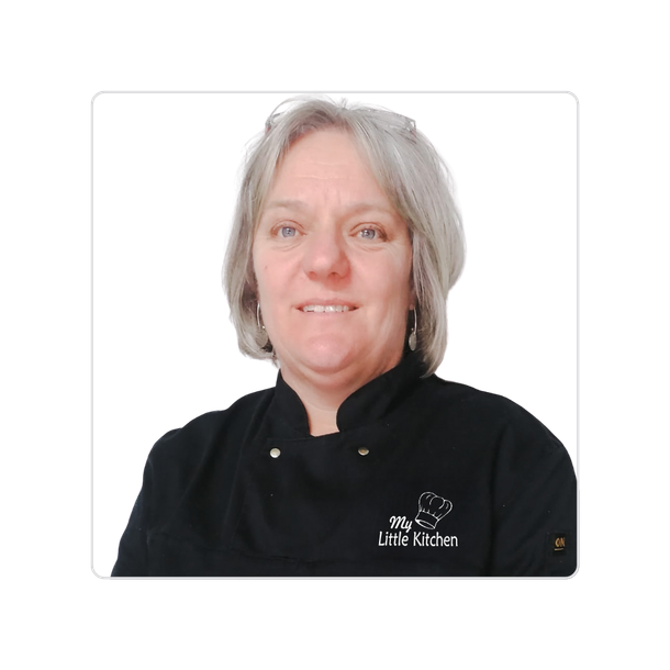 Person in a black chef coat against a white background, facing forward and smiling slightly