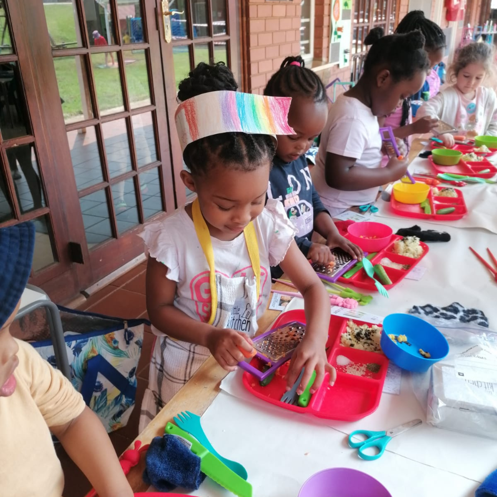 Children crafting at a table with colorful supplies in a classroom setting