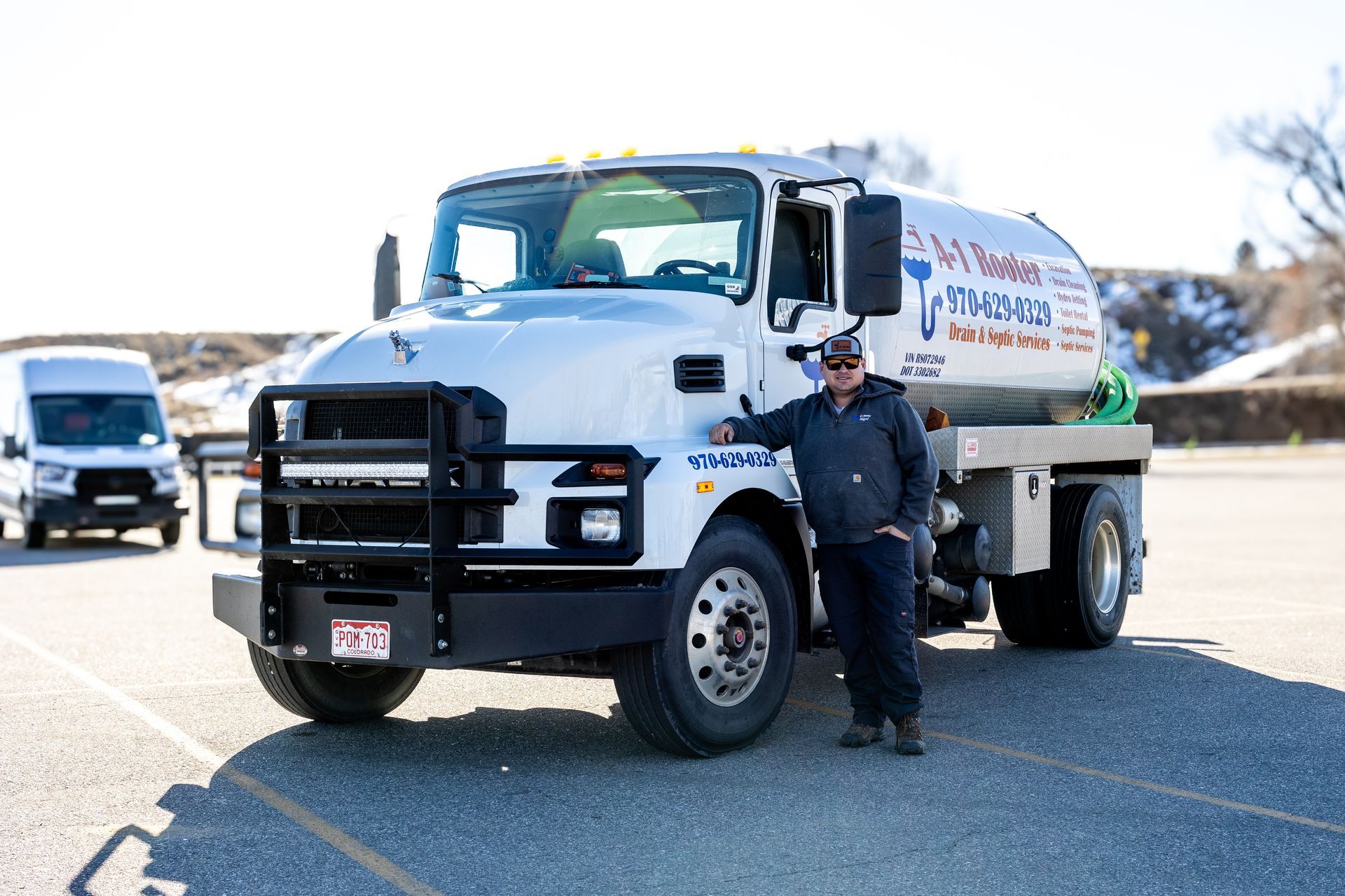 A man is standing next to a white truck in a parking lot.
