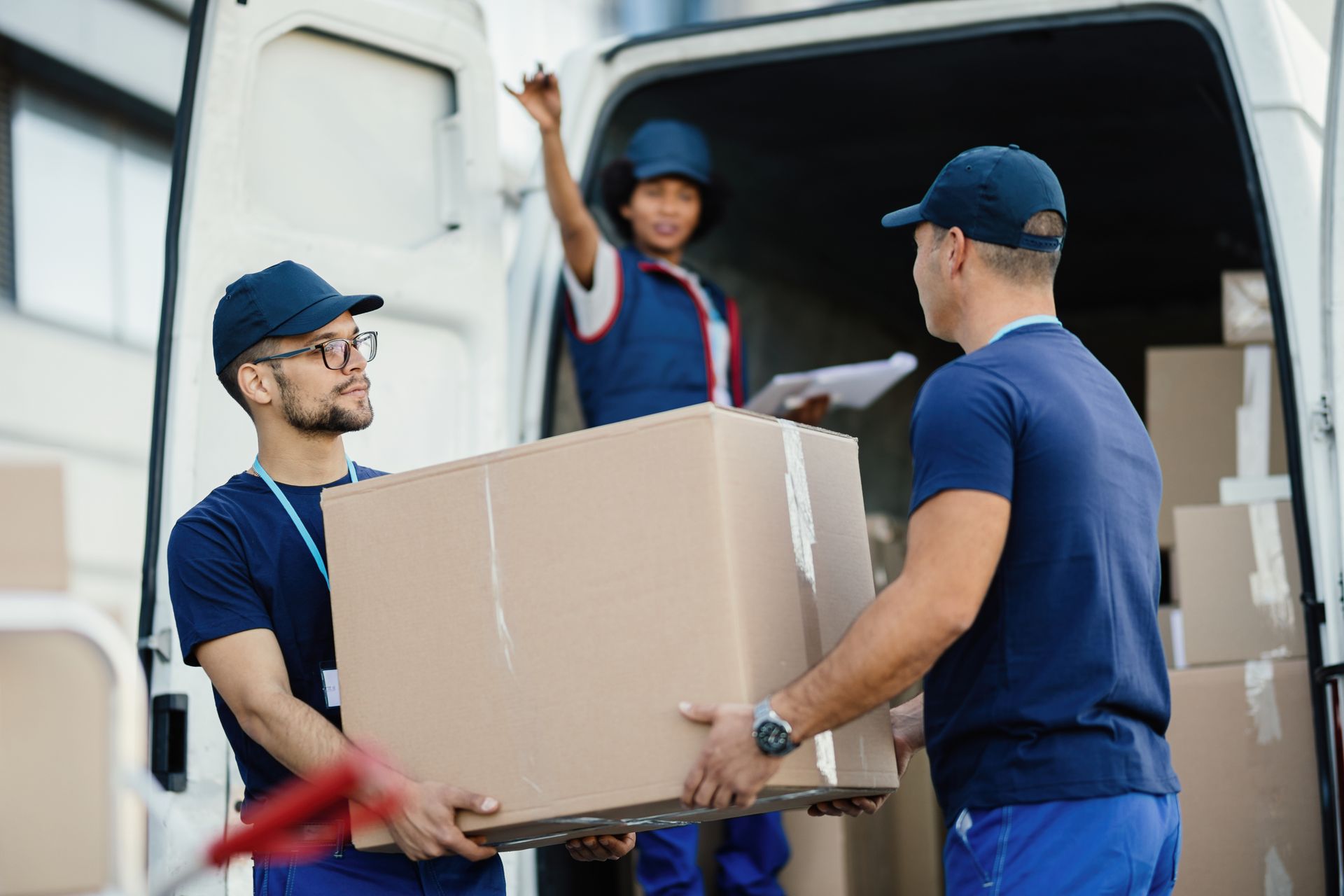 a man is carrying a cardboard box to another man