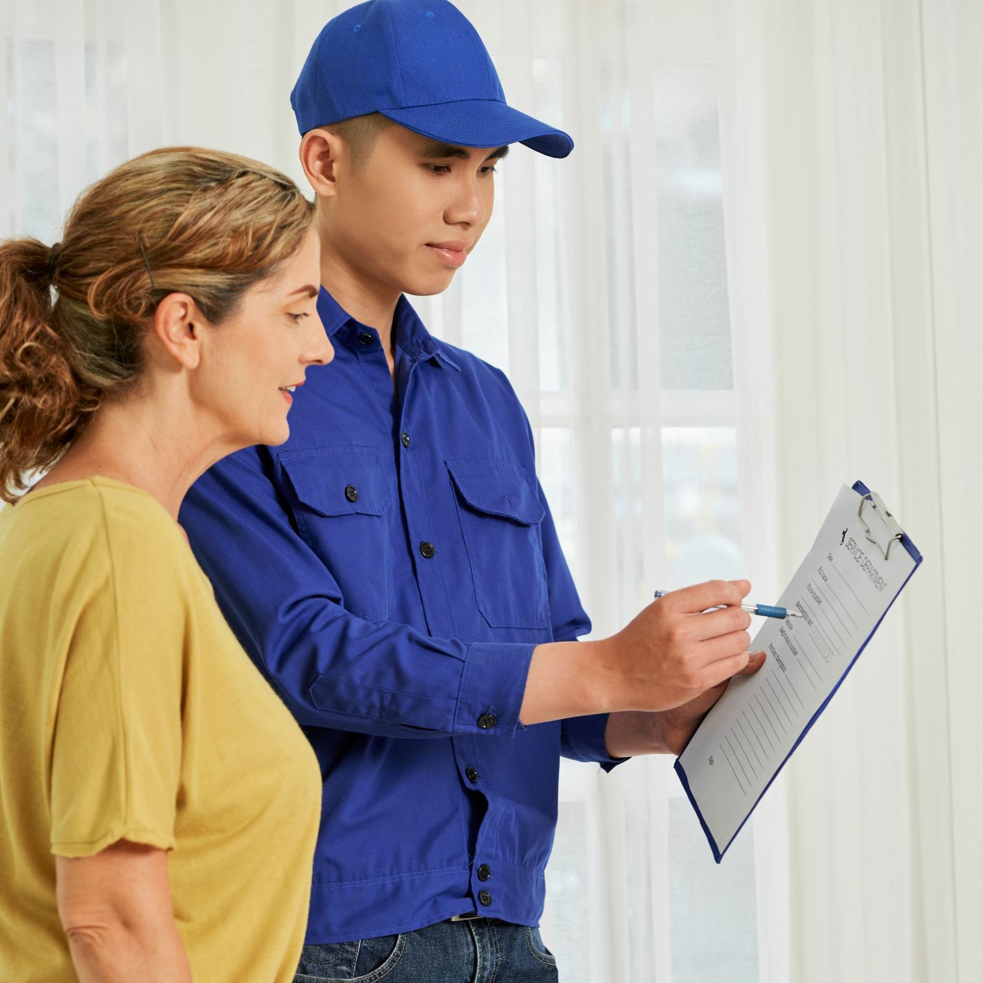 a man in a blue shirt is looking at a clipboard