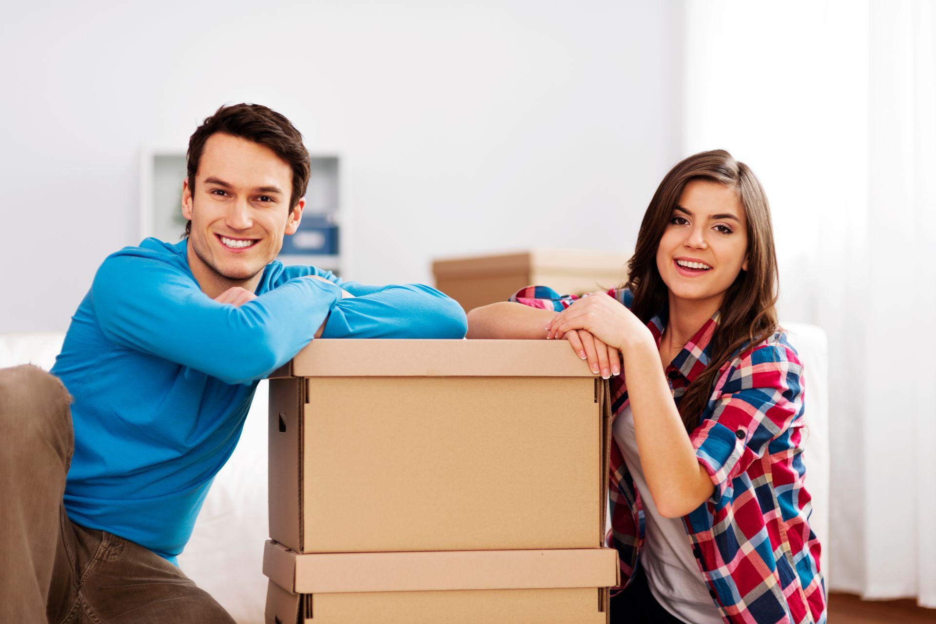 a man and a woman leaning on cardboard boxes