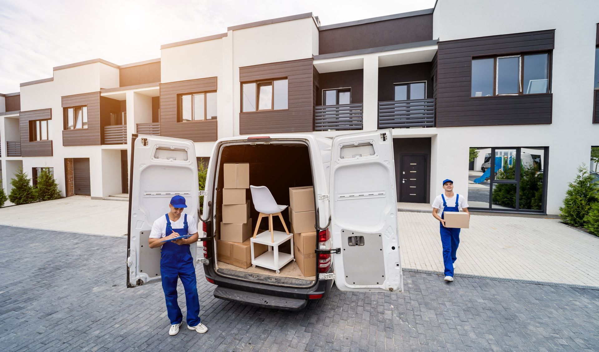 two men are loading boxes into a white van