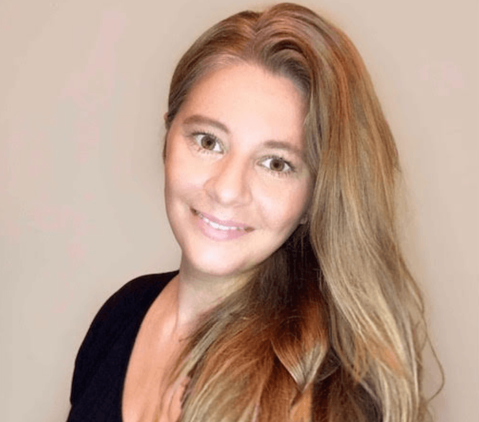 Smiling woman with long light brown hair against a beige background