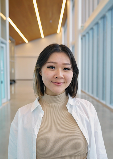 a woman in a white shirt is standing in a hallway .