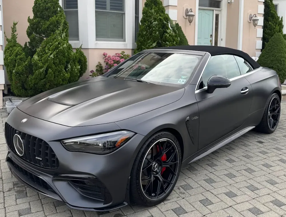 Matte gray Mercedes convertible parked on a driveway in front of a house