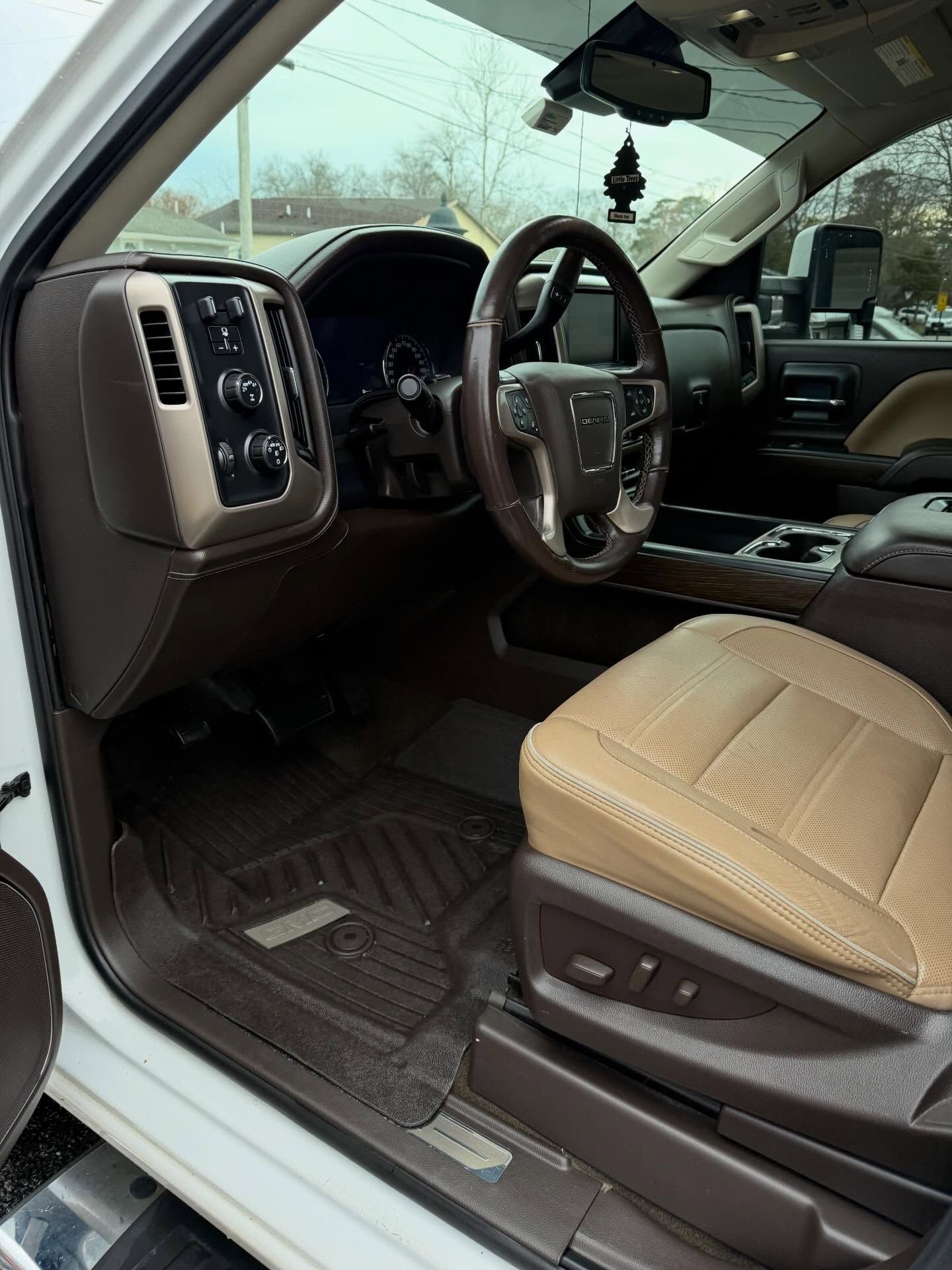 Pickup truck interior with tan leather seats, steering wheel, and dashboard seen from the driver’s side
