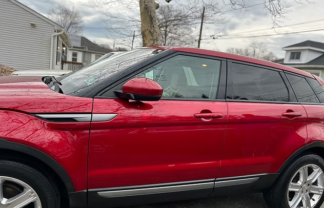 Red SUV parked in a residential driveway on an overcast day.