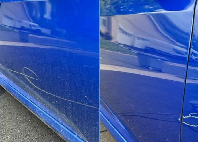 Blue car side panel with a long scratch and scuff near the bottom edge.
