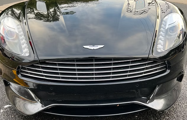 Front view of a black Aston Martin sports car parked on pavement