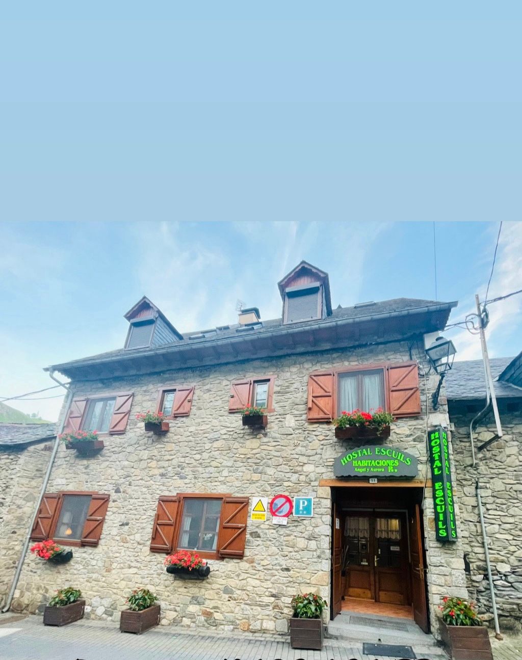 Un gran edificio de piedra con un cartel verde en el frente.