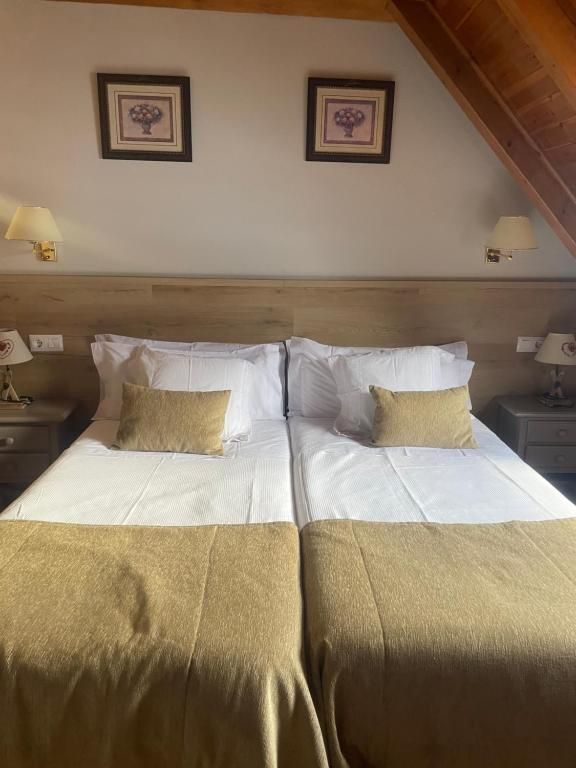 Una habitación de hotel con dos camas y dos lámparas.