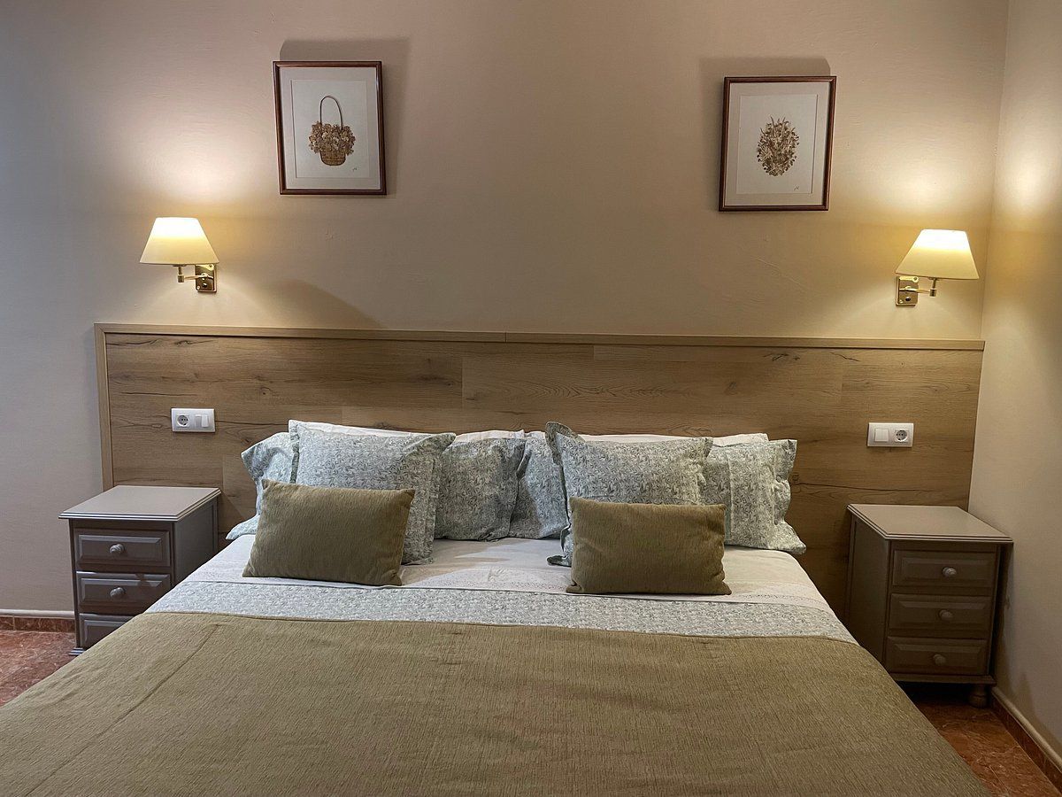 Un dormitorio con una cama grande y dos mesitas de noche.